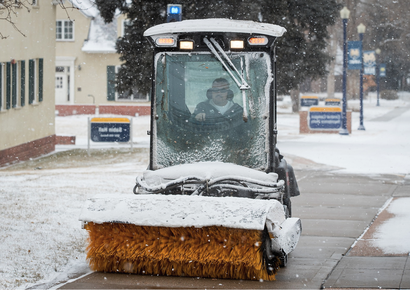 UNC faclitlies member clearing walkways of snow.